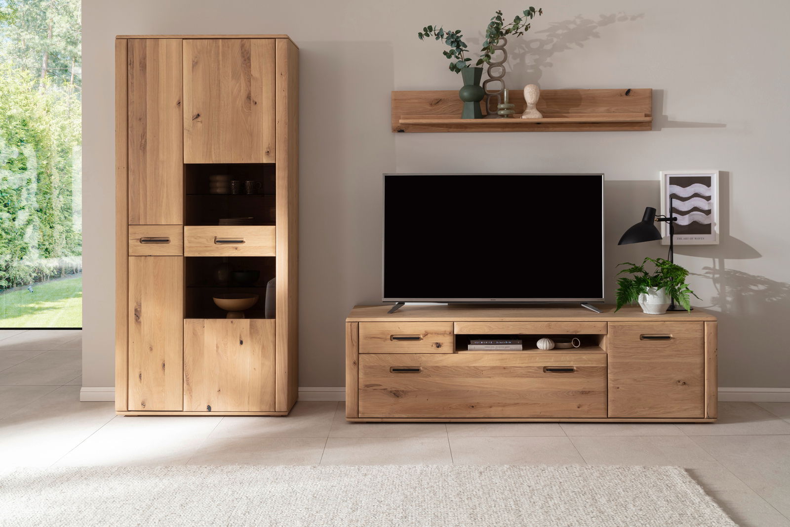 Wandkombination aus Holz mit Schrank, TV-Board und Regal, frontal fotografiert. Dekoriert mit Pflanzen und Dekorationsobjekten.
