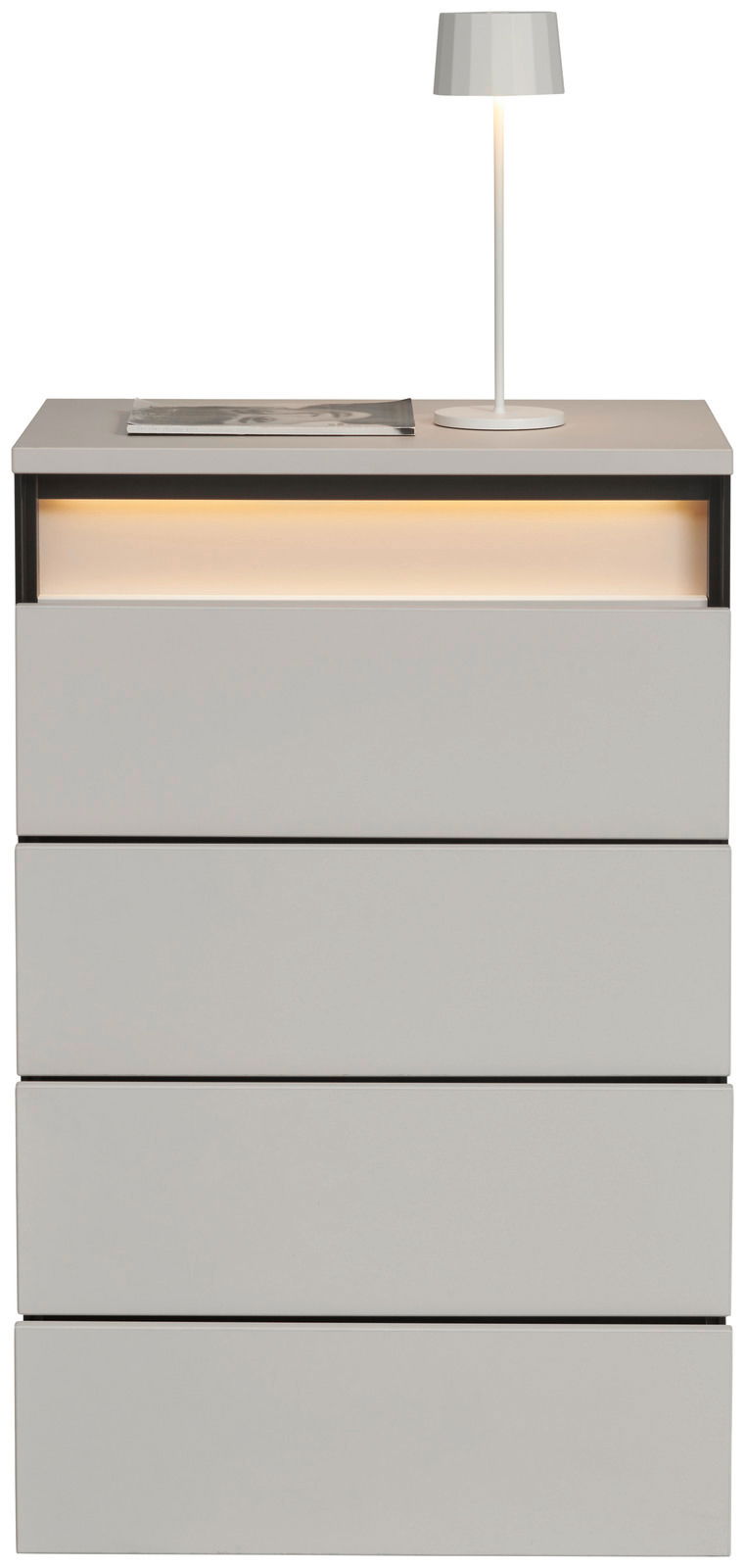 Hochkommode mit vier Schubladen, moderne graue Oberfläche, beleuchtetes Fach oben, Ansicht von vorne, dekoriert mit einer Tischlampe und einem Buch.