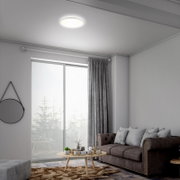 Moderne LED-Deckenleuchte in einem stilvollen Wohnzimmer, von unten betrachtet.