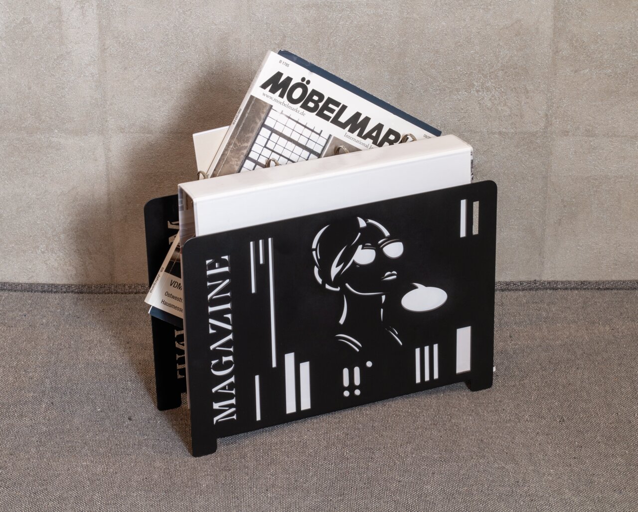 Schwarzer Zeitungsständer mit modernem Design, gefüllt mit Zeitschriften, seitliche Perspektive