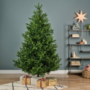Üppiger grüner Weihnachtsbaum in gerader Vorderansicht, stimmungsvoll in einem modernen Wohnzimmer mit verpackten Geschenken präsentiert