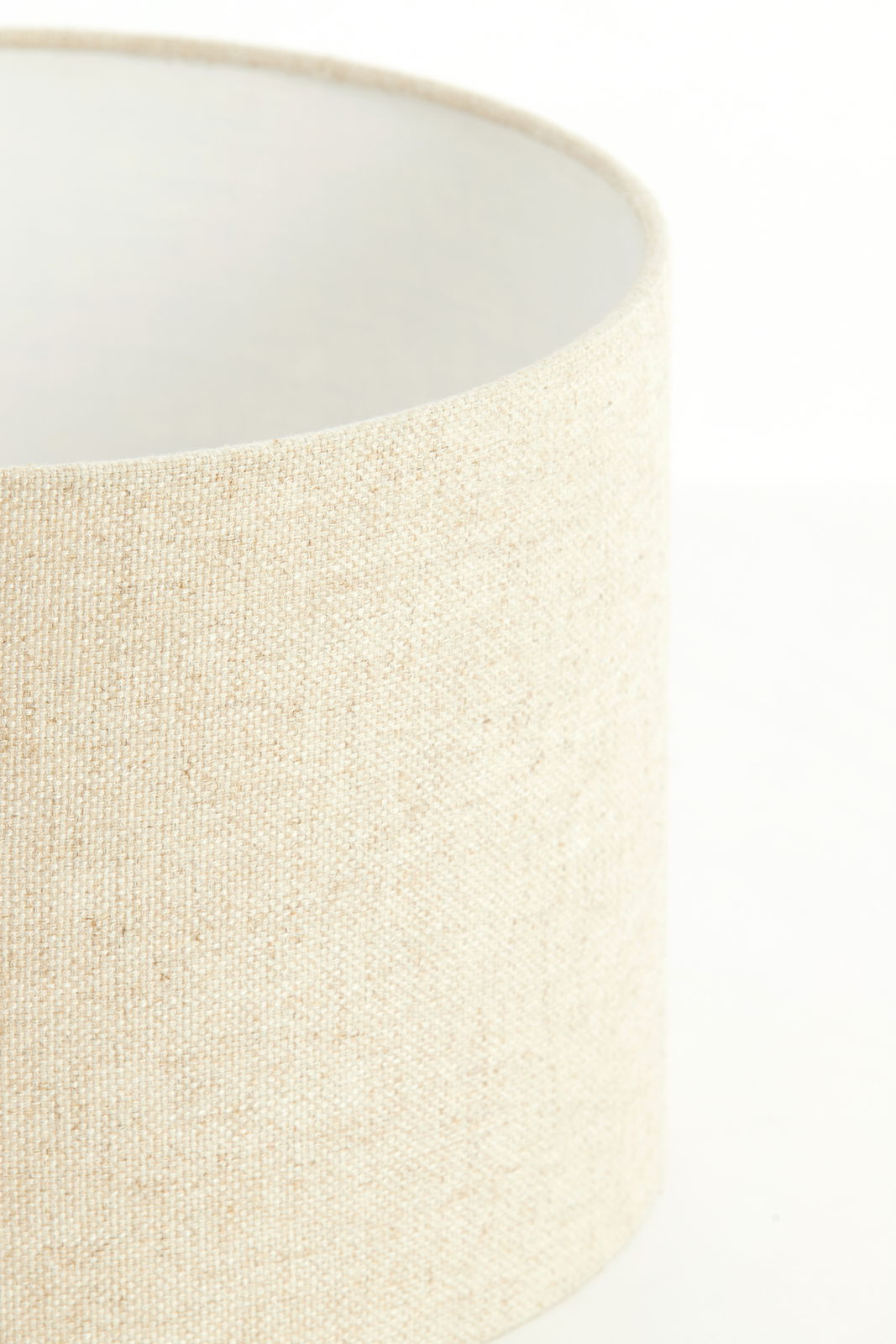 Nahaufnahme eines zylindrischen, cremefarbenen Lampenschirms mit texturierter Oberfläche, seitliche Perspektive.