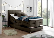 Modernes Boxspringbett in einem gemütlichen Schlafzimmer, seitliche Perspektive