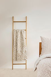 Wohndecke mit Leopardenmuster auf Holzleiter, seitliche Perspektive