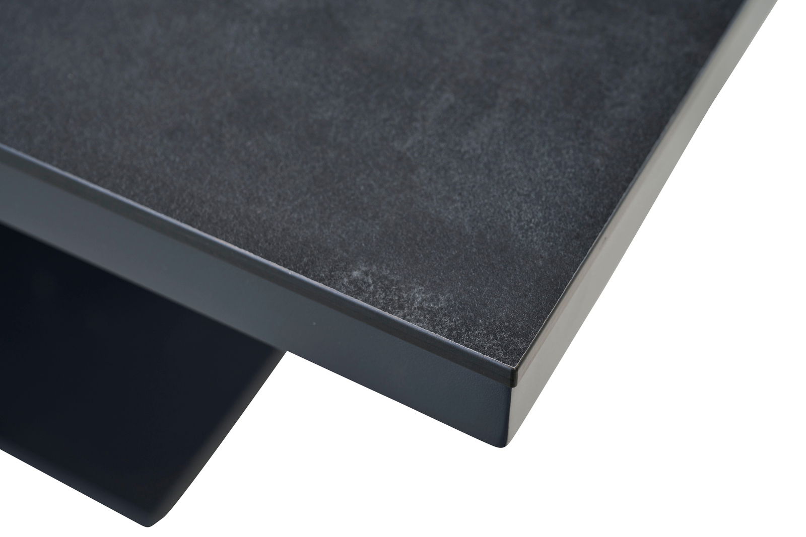 Nahaufnahme einer dunklen Tischplatte mit glatter Oberfläche, perspektivisch von oben rechts fotografiert.