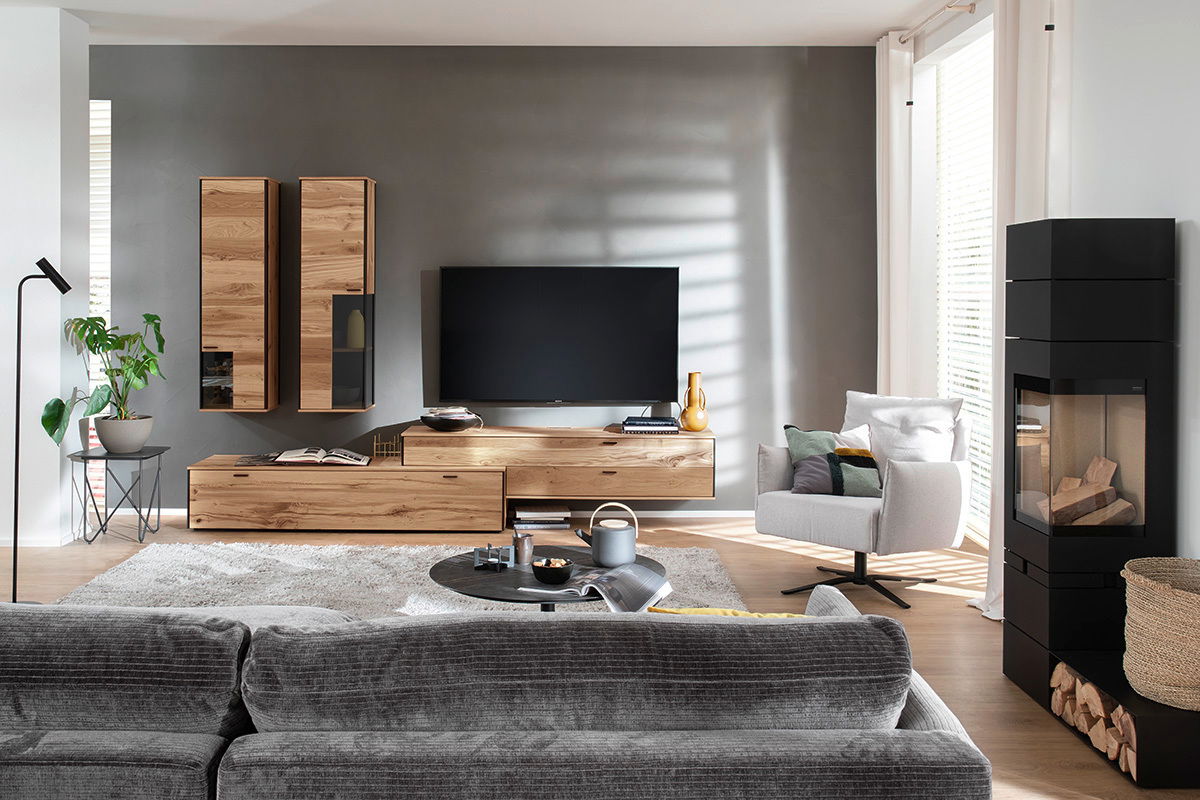Moderne Wohnzimmeransicht mit der Schöner Wohnen Wandkombination ANDRA in Holzoptik, bestehend aus hängenden Schränken und einem TV-Board, frontal betrachtet.