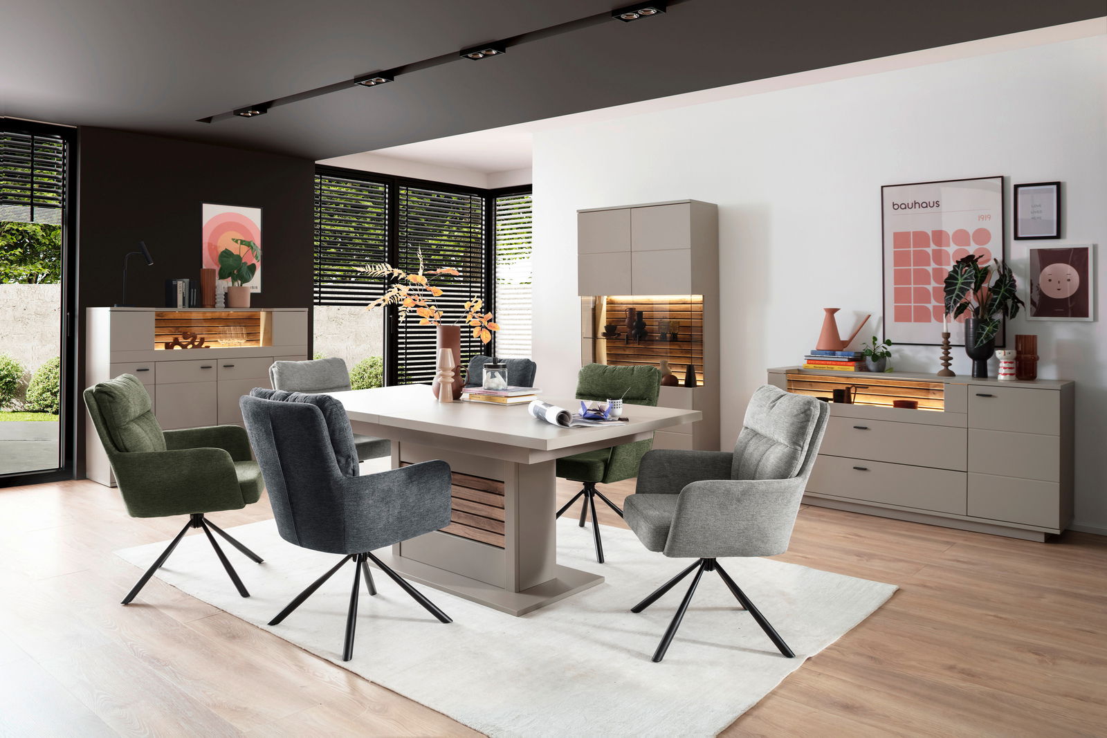 Moderne Esszimmer-Einrichtung mit Esstisch, umgeben von stilvollen Stühlen und beleuchteten Sideboards, aus der Perspektive des Raumes betrachtet.