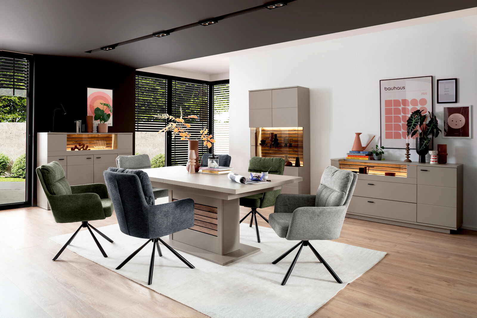 Moderne Esszimmer-Einrichtung mit Esstisch, umgeben von stilvollen Stühlen und beleuchteten Sideboards, aus der Perspektive des Raumes betrachtet.