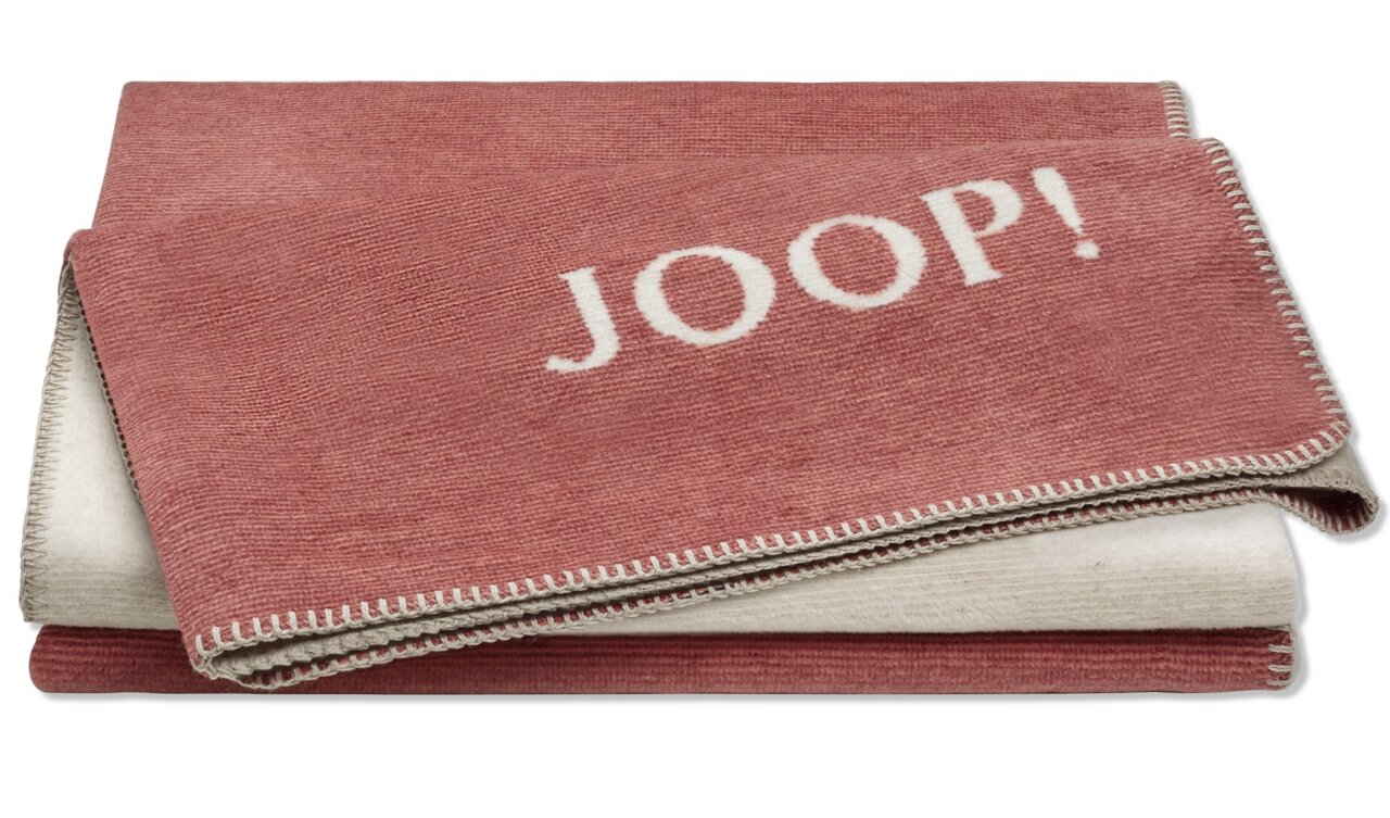 Rote Decke mit dem Schriftzug 'JOOP!' in Nahaufnahme, zeigt die doppelseitige Struktur und die feine Umrandung.