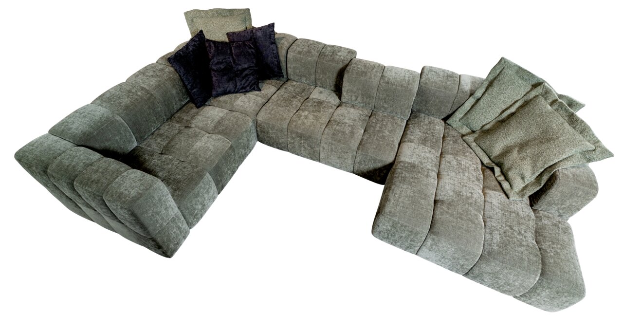 Grüne Polsterrundecke in L-Form mit mehreren Kissen, aus der Vogelperspektive fotografiert.