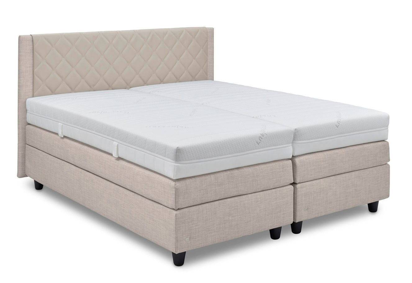 Boxspringbett in Beige mit gestepptem Kopfteil, seitliche Perspektive