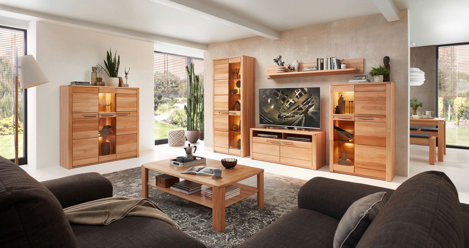 Wohnzimmer mit modernen Holzmöbeln, darunter ein TV-Lowboard, Vitrinen und ein Couchtisch, aus der Perspektive eines gemütlichen Sitzbereichs.