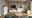 Modernes Wohnzimmer mit einem weißen Highboard, das von der Seite betrachtet wird. Es hat eine Holzoberfläche und ist von Pflanzen und Dekorationen umgeben.