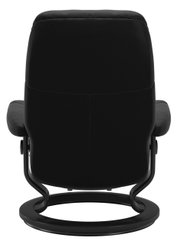Achterkant van een zwarte fauteuil met een rond metalen frame