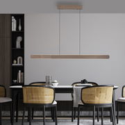 Moderne Pendelleuchte ADRIANA ROUND in Holzoptik, über einem Esstisch mit vier Stühlen, seitliche Perspektive.