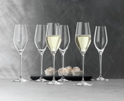 Sechs elegante Champagnerkelche der Serie Topline, zwei gefüllt mit Champagner, auf einer grauen Oberfläche mit einem modernen Hintergrund. Perspektive von vorne.