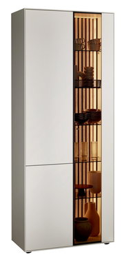 Standvitrine LUCIANO von Johann Jakob, linke Perspektive, mit Glas auf der rechten Seite, beleuchtete Regale mit dekorativen Objekten.