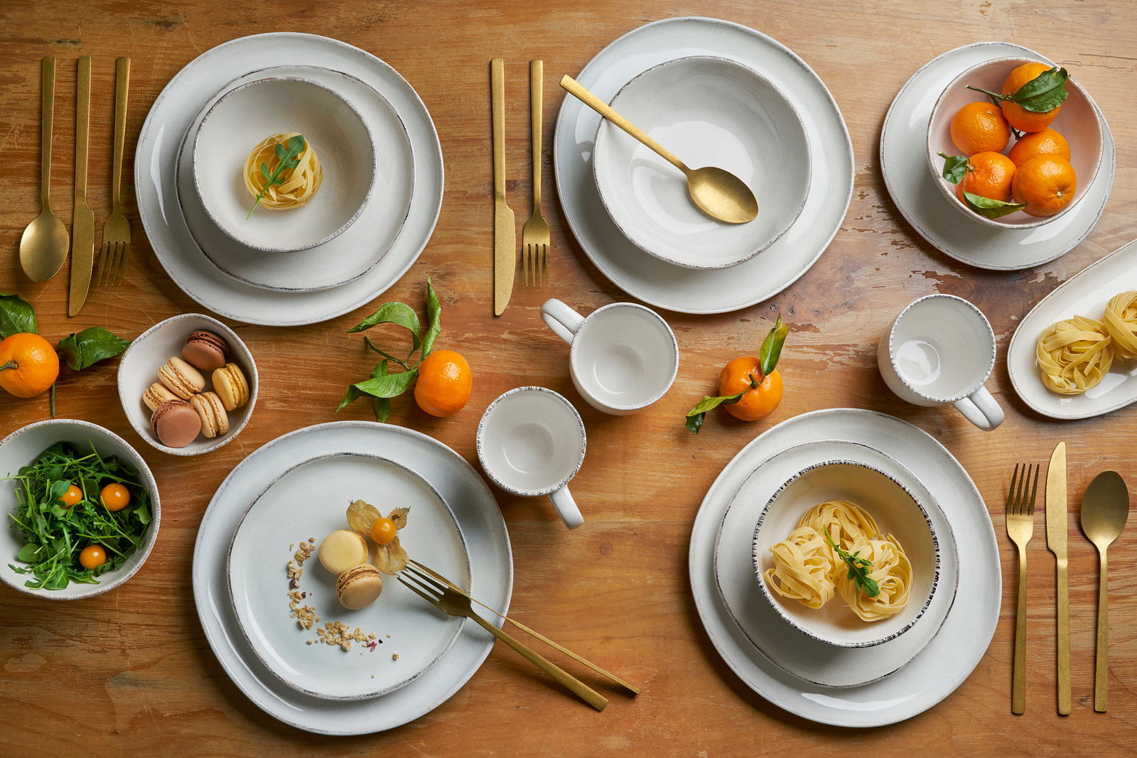 Kombiservice 16-tlg. in eleganter Tischdekoration mit goldfarbenem Besteck, von oben fotografiert.