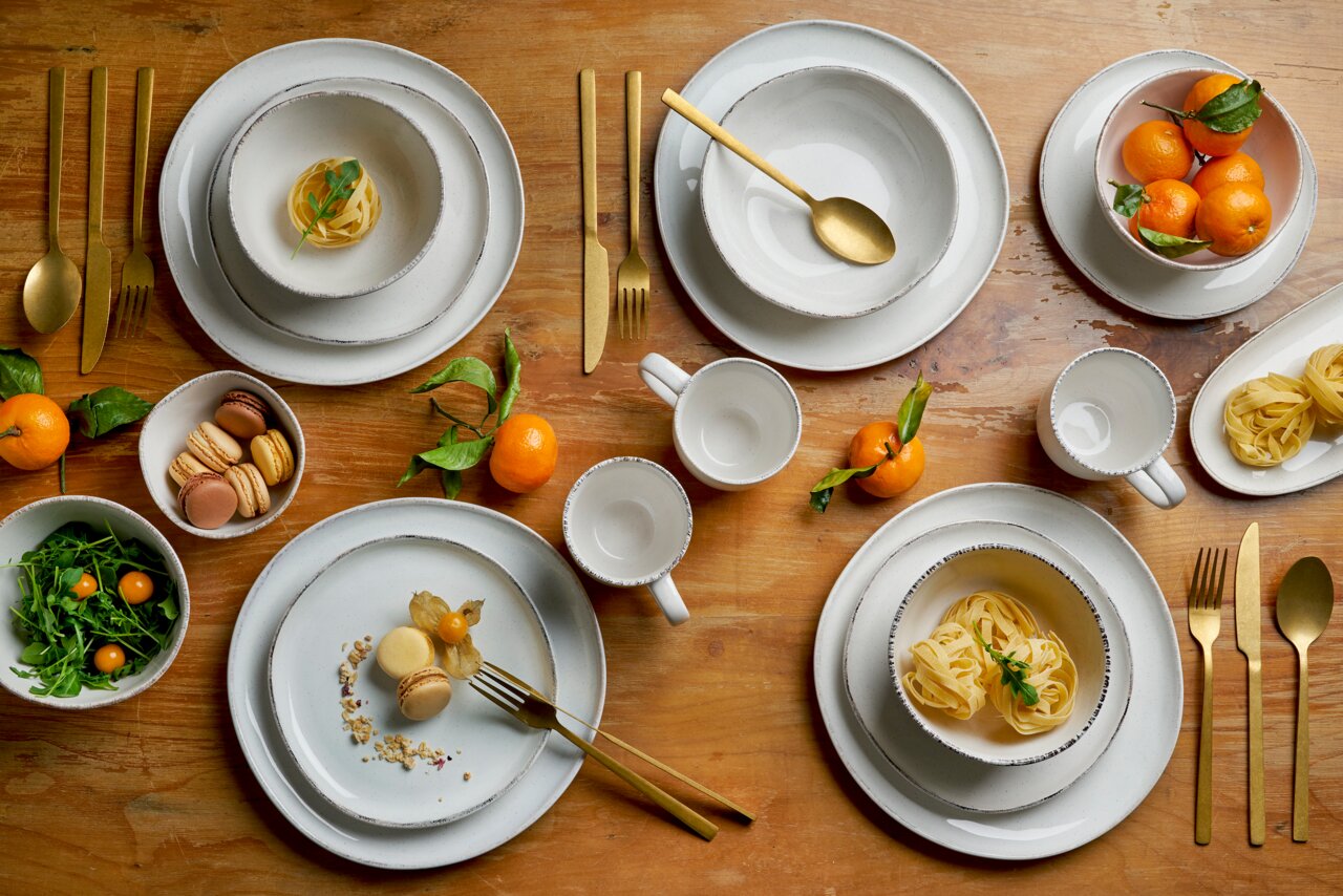 Kombiservice 16-tlg. in eleganter Tischdekoration mit goldfarbenem Besteck, von oben fotografiert.