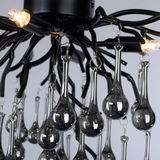 Nahaufnahme der Deckenleuchte ICICLE mit eleganten, tropfenförmigen Glaselementen und schwarzem Metallrahmen, von unten betrachtet.