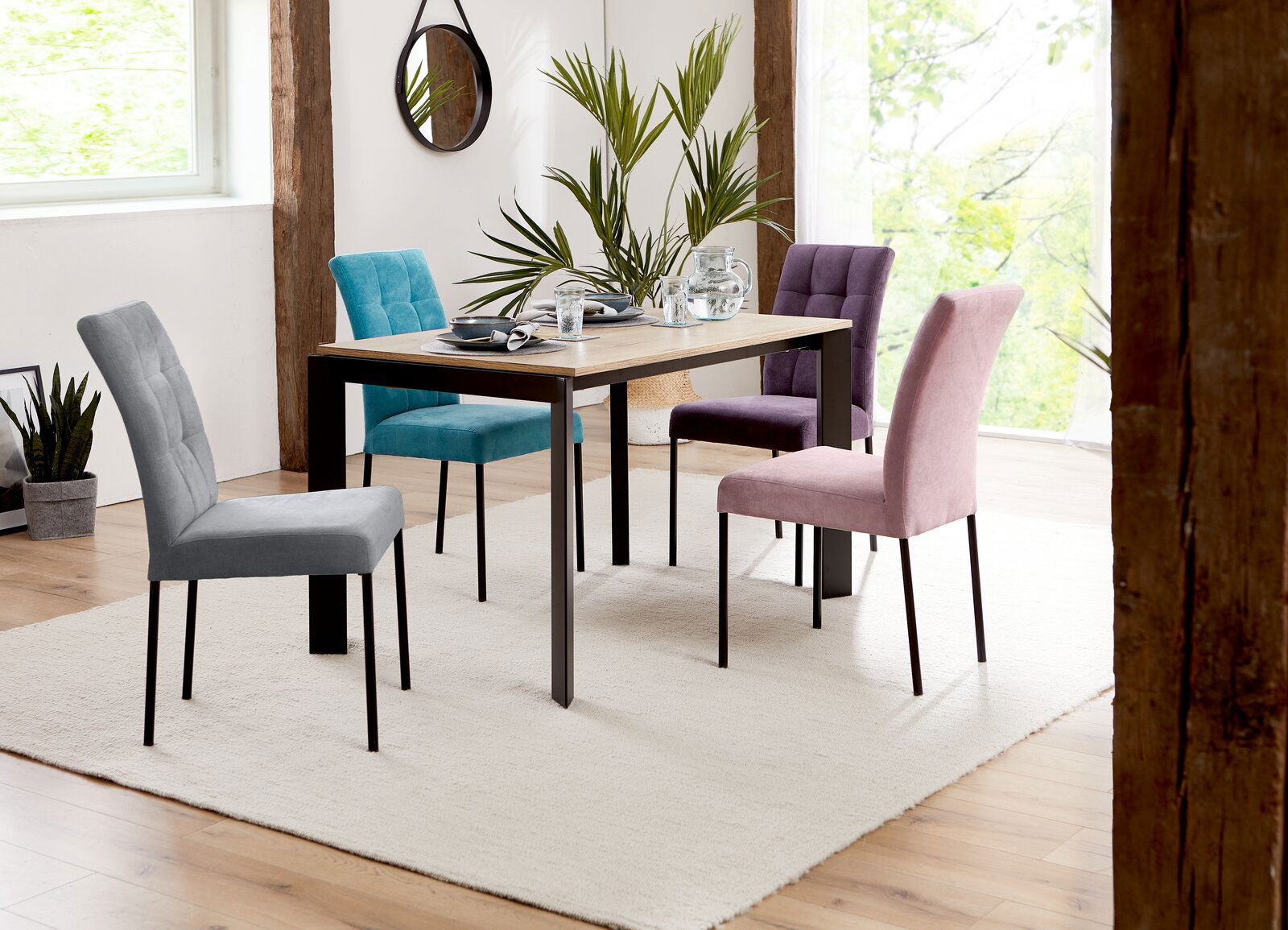 Moderner Esstisch mit vier bunten Stühlen in einem hellen Raum, seitliche Perspektive.