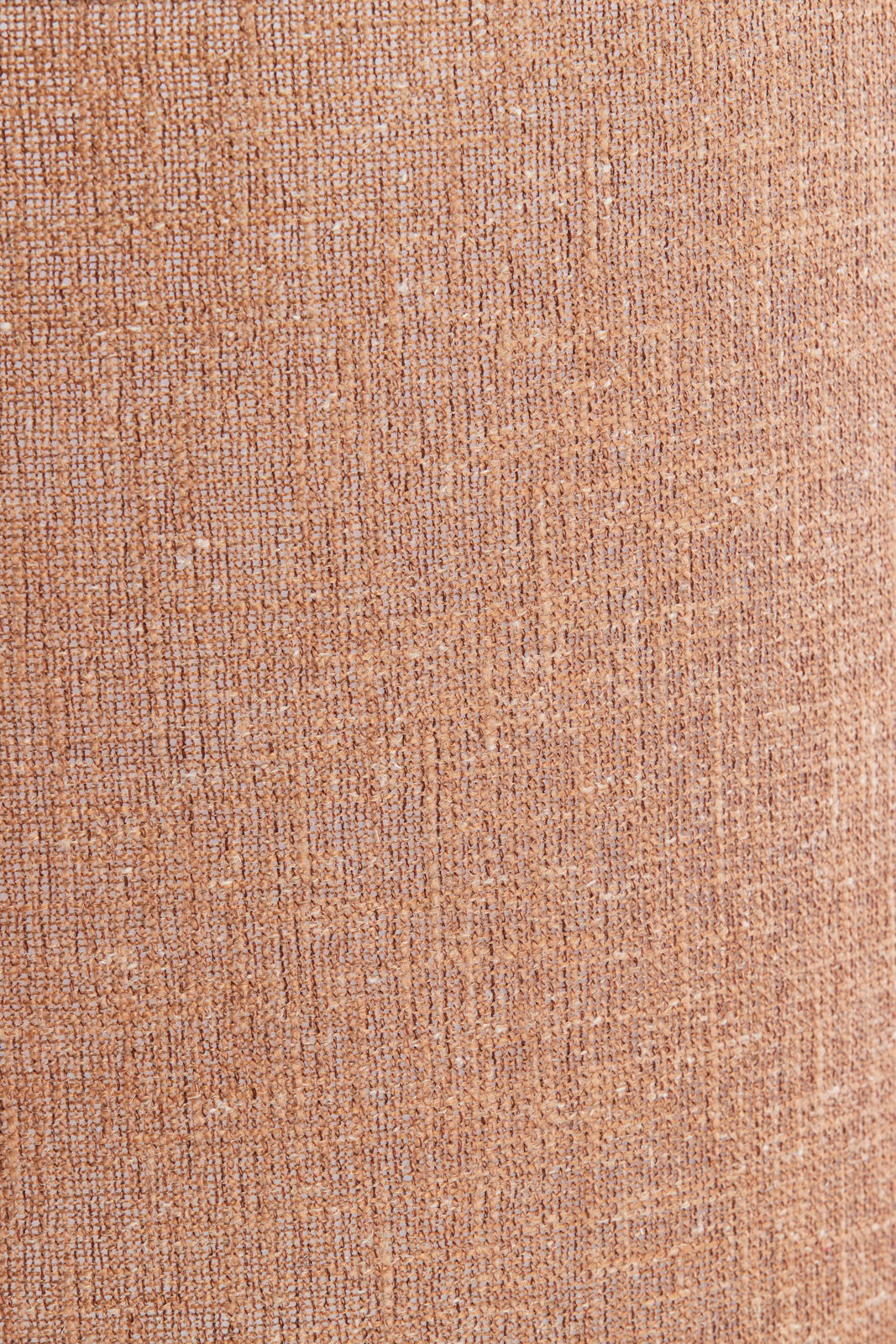 Nahaufnahme eines strukturierten, beige-braunen Lampenschirms aus Stoff.