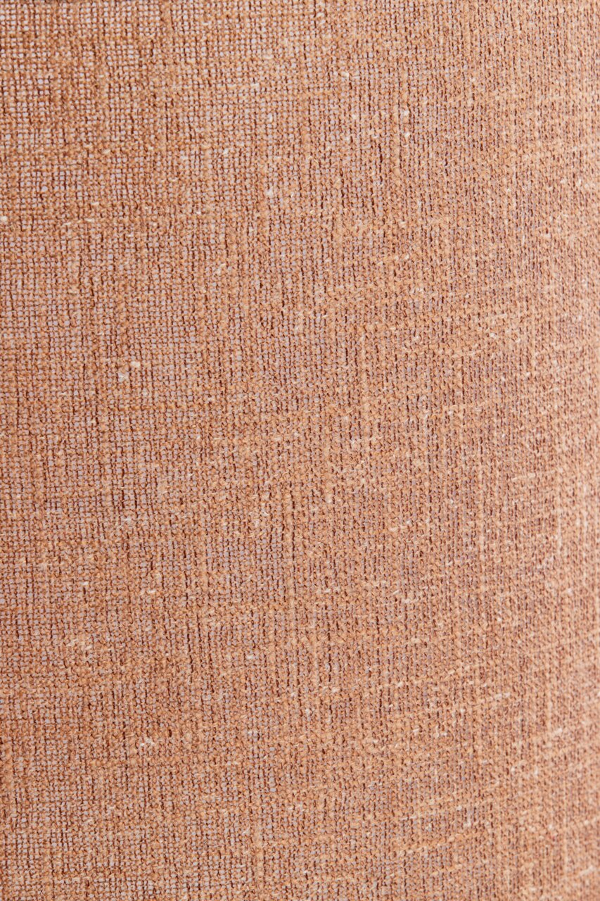 Nahaufnahme eines strukturierten, beige-braunen Lampenschirms aus Stoff.