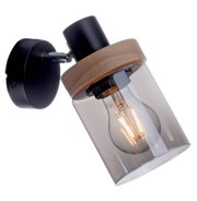 Schwarze Wandlampe im modernen Stil mit Holzring und klarem Glaszylinder, sichtbares Leuchtmittel, seitliche Nahaufnahme in schräger Perspektive