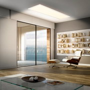 Rechthoekig LED plafondpaneel in een moderne woonkamer, warm wit licht, gezien schuin van onderen (plafondperspectief)