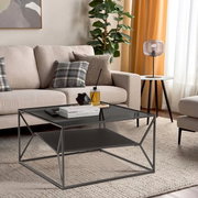 Moderner Beistelltisch mit Glasplatte und Metallrahmen in einem stilvollen Wohnzimmer, seitliche Perspektive.