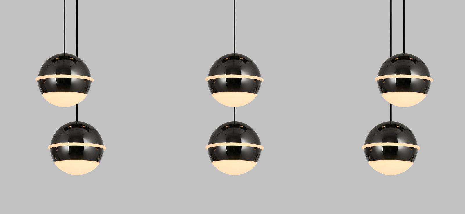 Moderne LED-Pendelleuchte mit kugelförmigem Design, in einer frontalen Perspektive gezeigt, bestehend aus drei schwarzen, glänzenden Kugeln mit leuchtenden unteren Hälften, aufgehängt an dünnen Kabeln.