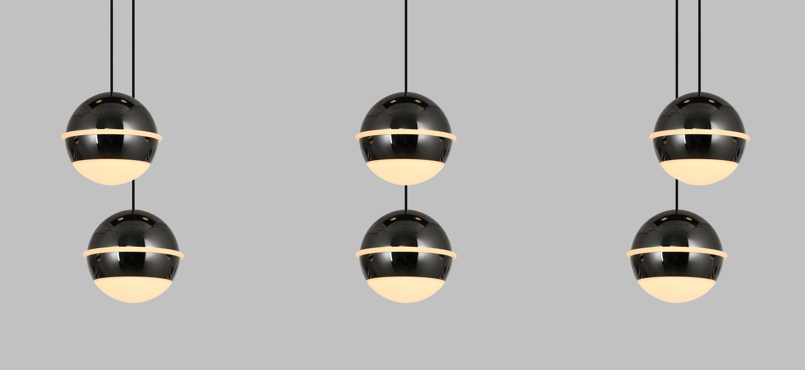 Moderne LED-Pendelleuchte mit kugelförmigem Design, in einer frontalen Perspektive gezeigt, bestehend aus drei schwarzen, glänzenden Kugeln mit leuchtenden unteren Hälften, aufgehängt an dünnen Kabeln.