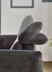 Nahaufnahme eines grauen Megasofas mit geripptem Stoffbezug, seitliche Perspektive