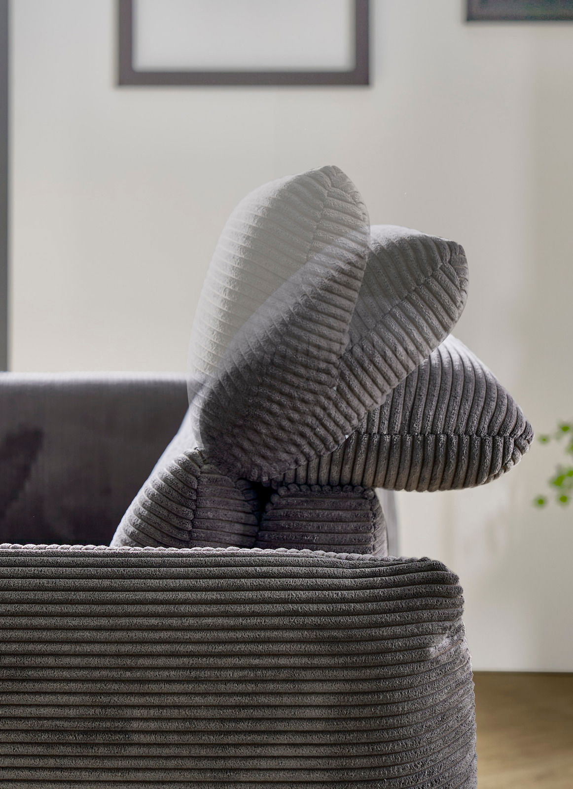 Nahaufnahme eines grauen Megasofas mit geripptem Stoffbezug, seitliche Perspektive