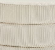 Nahaufnahme eines cremefarbenen, gerippten Hockers aus Stoff, seitliche Perspektive