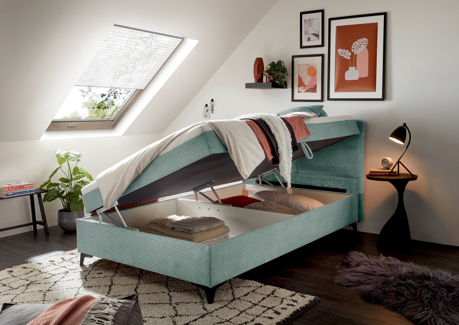 Boxbed met opklapbare opbergruimte, zijaanzicht, in een modern ingerichte slaapkamer onder een schuin dak.