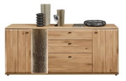 Frontaanzicht van een brede houten dressoir/commode met twee kastdeuren links en rechts, drie lades in het midden en een decoratieve verticale steen- of betonlook strook, met zwarte handgrepen en decoratie bovenop.