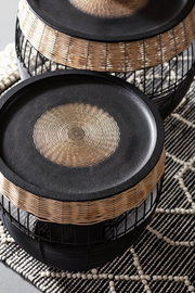 Zwei runde Beistelltische mit schwarzer Oberfläche und geflochtenem Rand, aus der Vogelperspektive fotografiert.