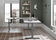 Moderner E-Eckschreibtisch in einem stilvollen Büro, seitliche Perspektive, mit Computer und Schreibtischzubehör.