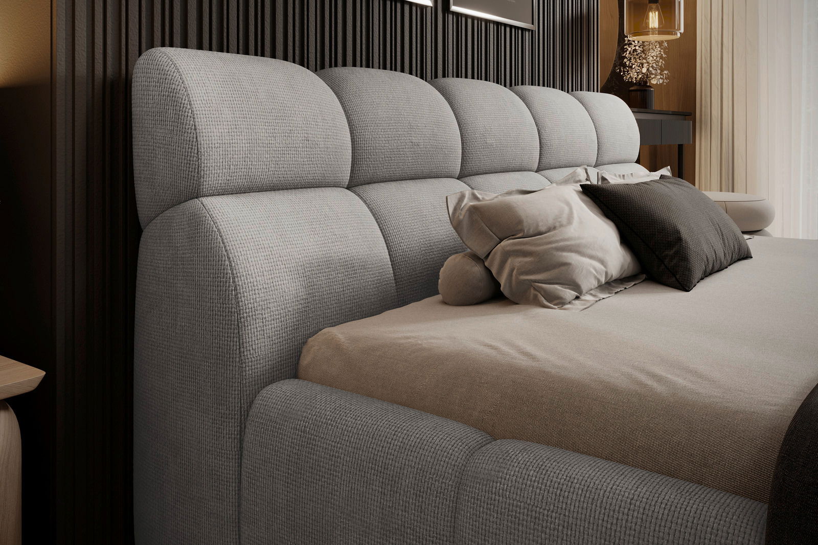 Seitliche Perspektive eines modernen Polsterbetts mit grauem Kopfteil und mehreren Kissen.