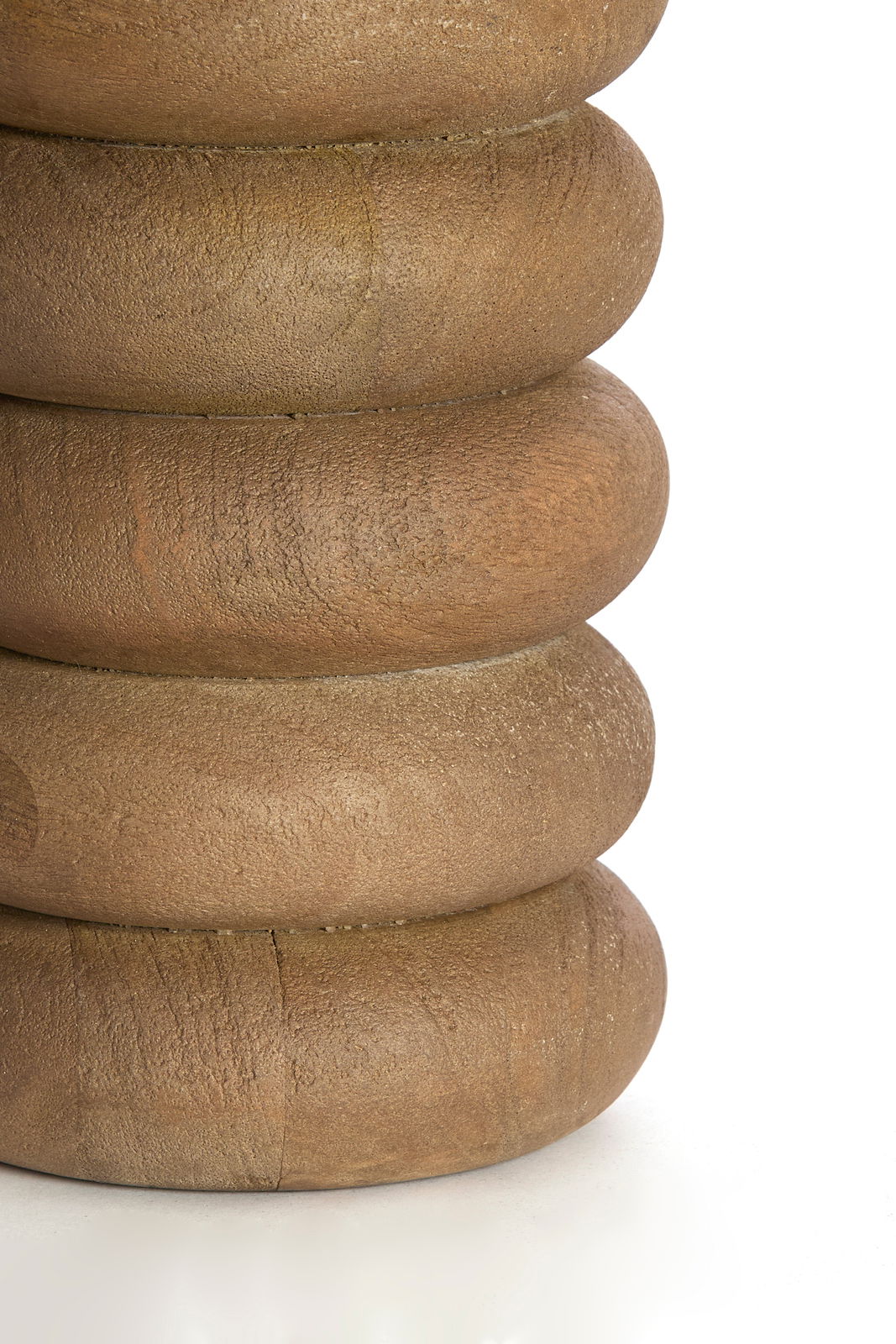 Nahaufnahme eines runden, gestapelten Holzlampenfußes mit natürlicher Maserung, seitliche Perspektive