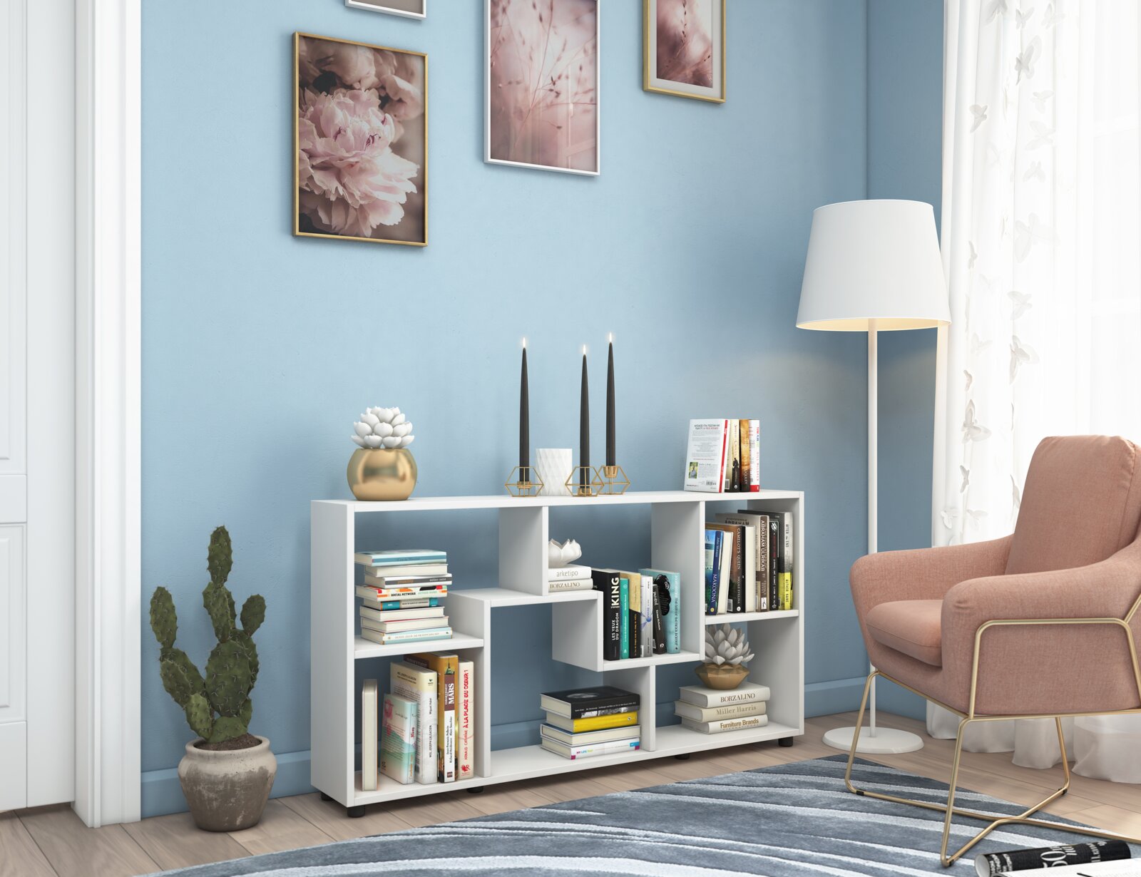 VCM Sideboard PINTAL Weißes, modernes Regal/Sideboard mit offenen Fächern und Büchern, dekoriert mit Kerzenhaltern und Pflanzen, im Wohnzimmer vor blauer Wand neben Stehlampe und rosa Sessel; Perspektive: frontale Ansicht auf Augenhöhe.