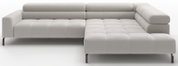Lichtgrijze gestoffeerde hoekbank met chaise longue rechts, doorgestikte kussens en zwarte metalen poten, getoond in vooraanzicht licht schuin van voren