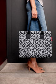 Person hält eine Tasche mit Leopardenmuster in der Hand, seitliche Perspektive