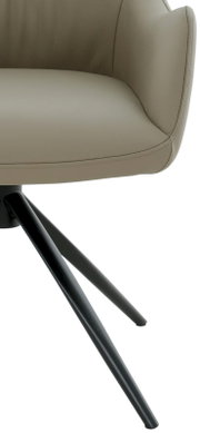 Close-up van een moderne fauteuil met beige lederen bekleding en zwarte metalen poten, gezien vanaf de zijkant