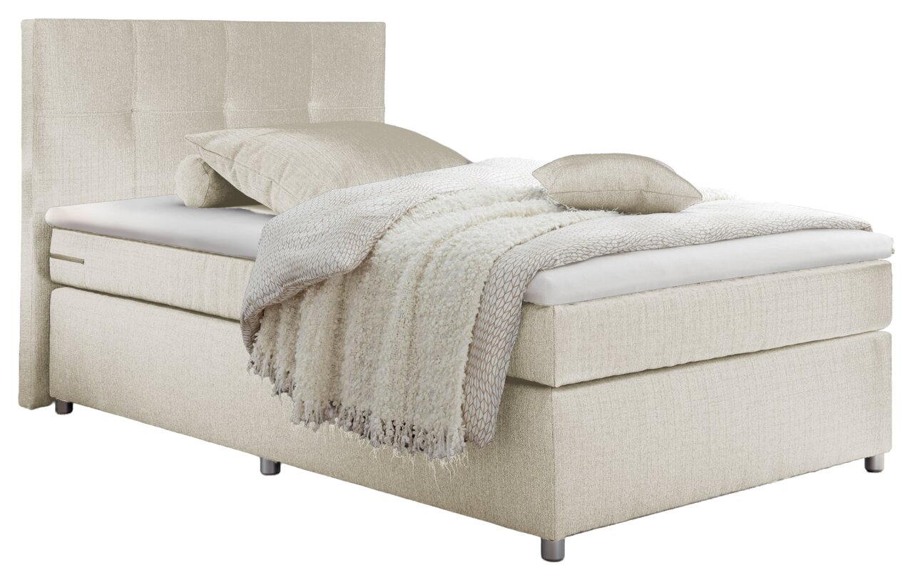 Beiges Boxspringbett mit Kopfteil, seitliche Perspektive, dekoriert mit Kissen und Decke