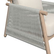 Detailansicht eines Lounge-Sessels mit hellem Holzrahmen und geflochtenem Seil-Design an der Seite.