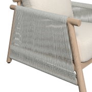 Detailansicht eines Lounge-Sessels mit hellem Holzrahmen und geflochtenem Seil-Design an der Seite.