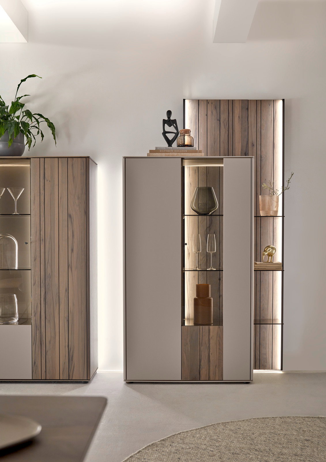 Modernes Highboard mit Holz- und Glaselementen, dekoriert mit Vasen und Skulpturen, seitliche Perspektive