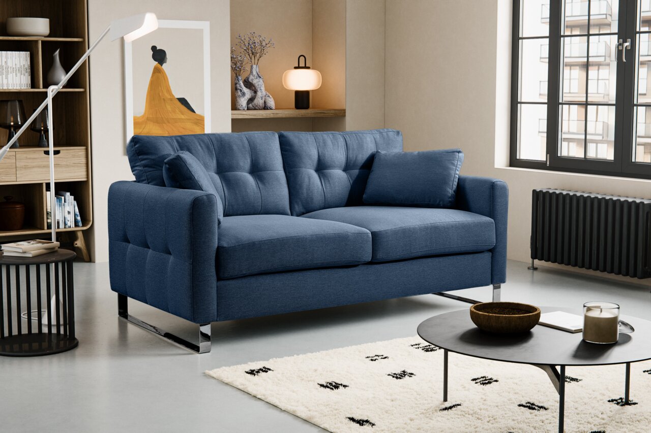 MID.YOU 2-Sitzer HERA Blaues, modern gepolstertes 2-Sitzer-Sofa mit Steppung, zwei Kissen und verchromten Metallfüßen im Wohnzimmer, schräg von vorne links fotografiert.